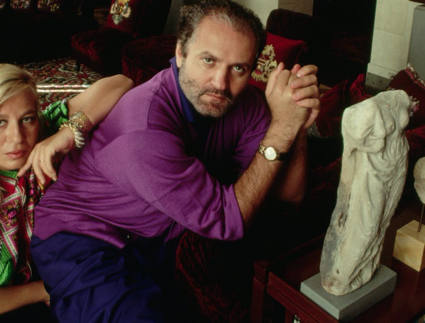 two people domestic scene adult fashion design italian southern european descent visual arts prominent persons brother male wealth female opulence sculpture sister art collector fashion designer milan donatella versace gianni versace person human couch furniture clothing apparel
