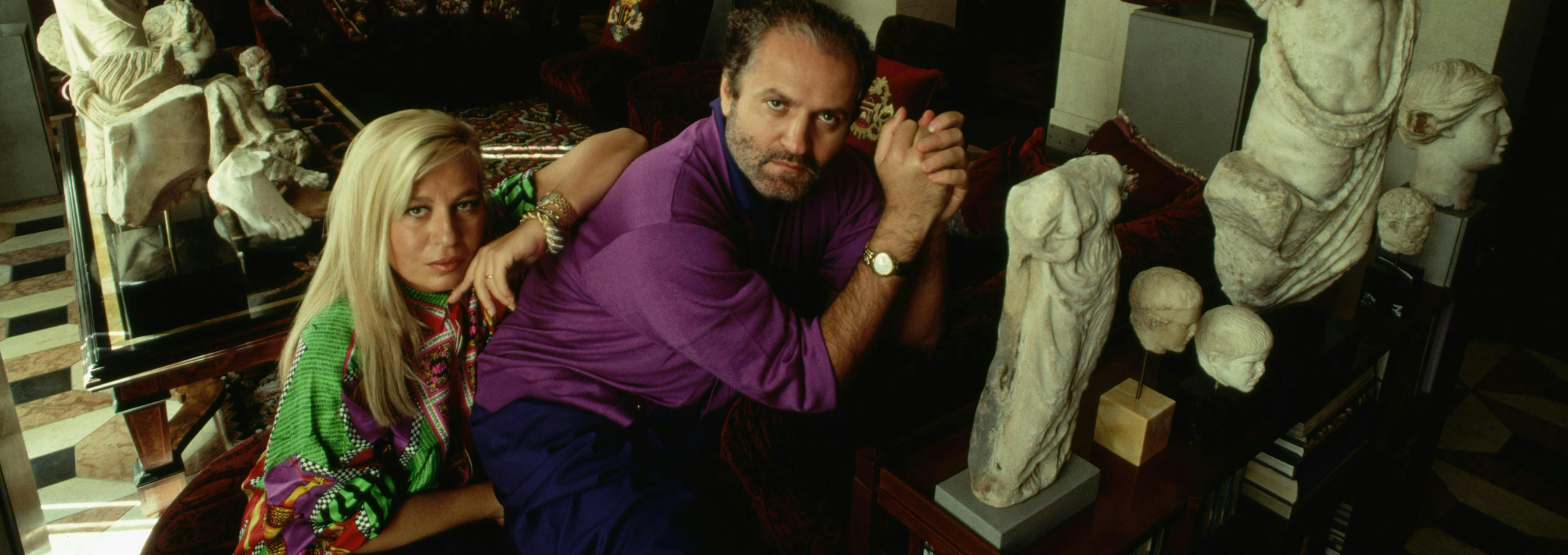 two people domestic scene adult fashion design italian southern european descent visual arts prominent persons brother male wealth female opulence sculpture sister art collector fashion designer milan donatella versace gianni versace person human couch furniture clothing apparel